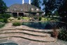 Swimming pool with an all flagstone deck and a spa spilling into the pool.
