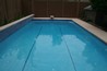 A rectangle diving pool with tiled swim lanes and a tiled raised wall.