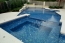 An all tiled pool and spa with a built in swim up bar.