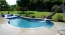 Curve shape pool with a raised spa and raised tanning ledge.