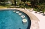 Swim up bar with in pool stools and granite counter top.