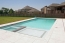 A rectangle pool with a spa and Greek style key way tile.