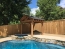 A covered structure next to a spa spilling into a pool.