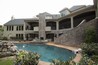 A large pool with a spa built next to a fireplace.