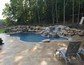 Free form pool with boulder waterfalls and hidden spa.