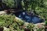 Pool with a boulder waterfall and raised decking.