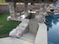 Sunken kitchen by swimming pool with bar stools