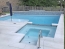 Rectangle pool with a spa and raised tiled wall with waterfalls.