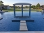 Travertine steps pads out to a perimeter overflowing spa.