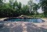 Pool with a stamped concrete deck and a boulder waterfall.