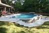 Bi-level decking around a pool with a waterfall.