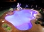 Free form pool with L.E.D. lighted laminar jets.