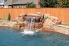 Boulder waterfall spilling into a pool.