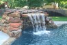 Boulder waterfall spilling into a pool.